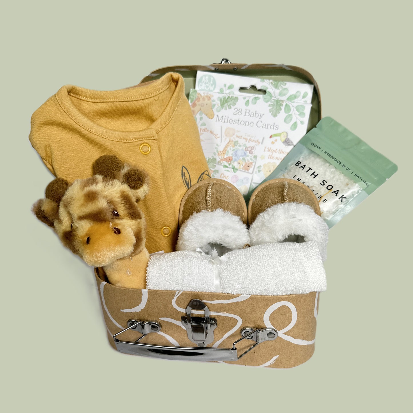 Baby shower gift case with baby rattle, bath salts, baby romper, baby slippers and milestone cards.