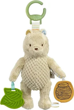 Winnie the pooh on the go activity toy. Plush toy with green clip and leaf-shaped tag on a white background