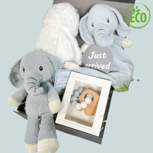 Blue and white new baby boy hamper contained in a grey baby keepsake box, a Blue and white elephant rattle toy with embroidered eyes and trunk and a matching Ely elephant baby blankie comforter. A white baby pompom hat made from recycled plastics, a "Just arrived" baby photography disc and a Bambino silicone and beech wood baby teether in blue and white with a wooden elephant shaped teether.