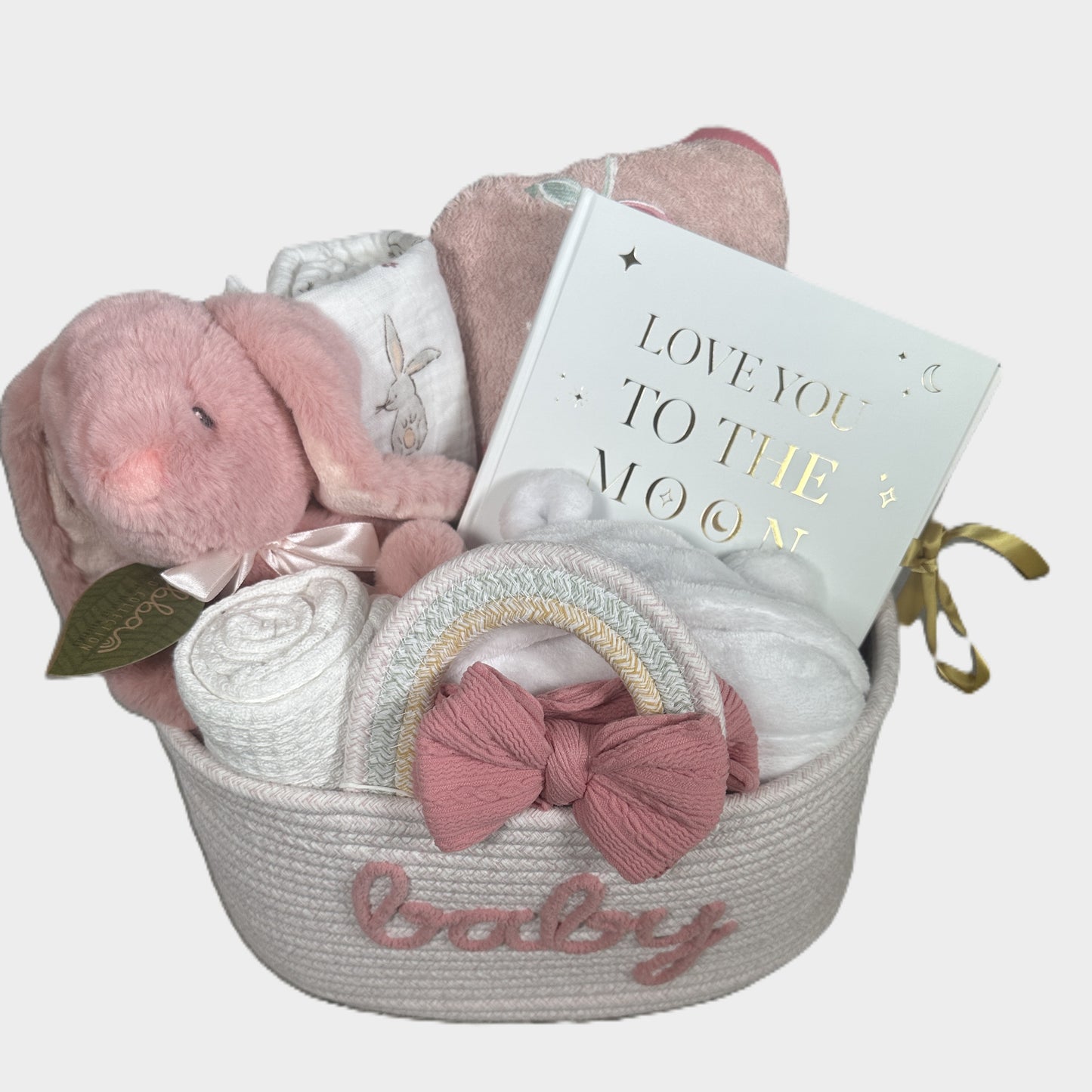 Baby gift basket with plush Bunny baby soft toy, bunny print baby swaddle blanket, and baby phot album in a basket on a white background