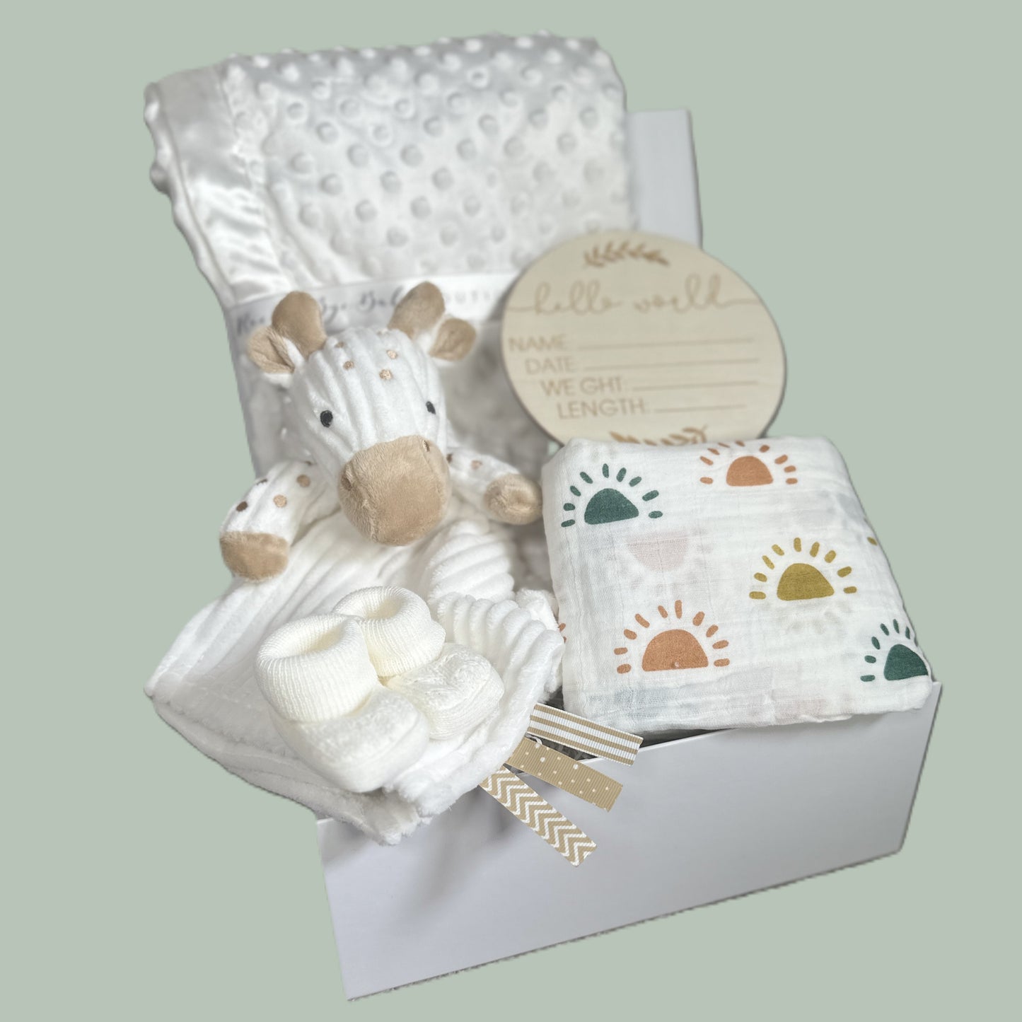 Baby gift set with plush toy giraffe comforter white baby, blanket, and muslin square in a baby keepsake box on a light green background