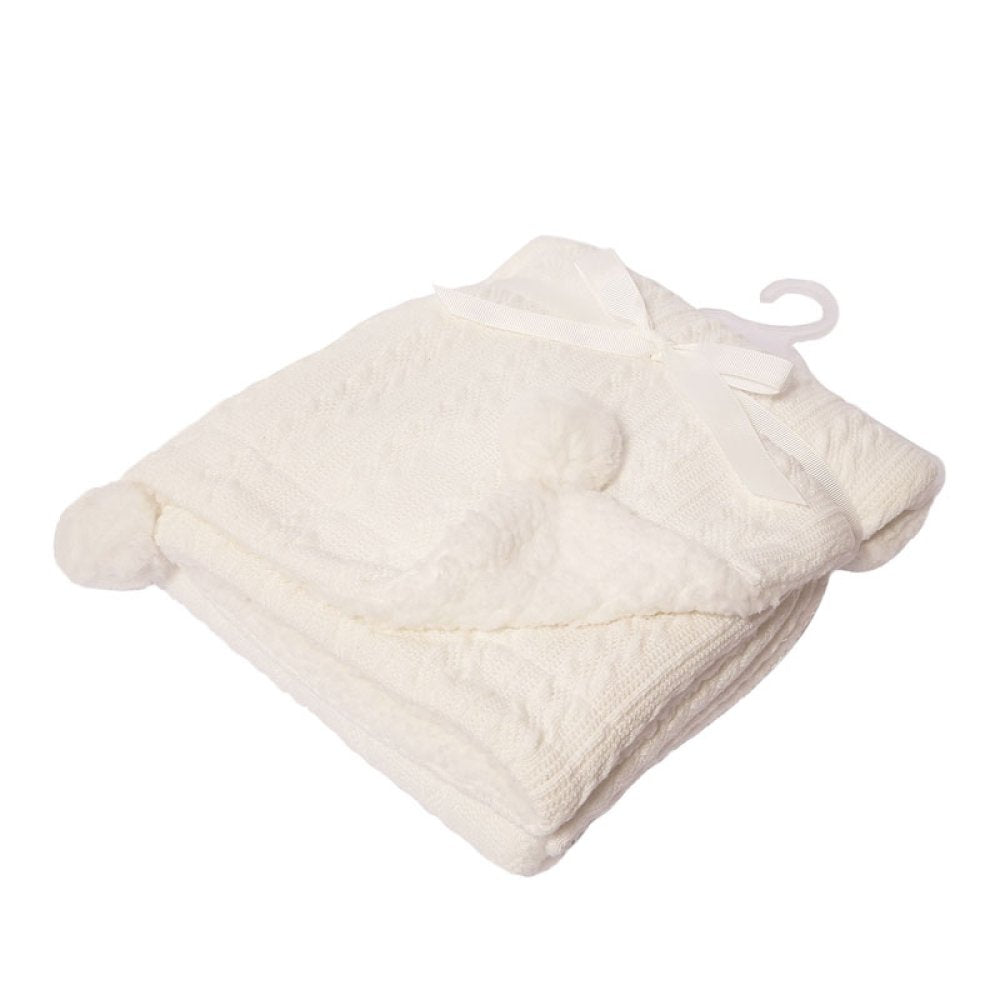 white cable knit pattern baby blanket with sherpa lining and 2 pompoms.