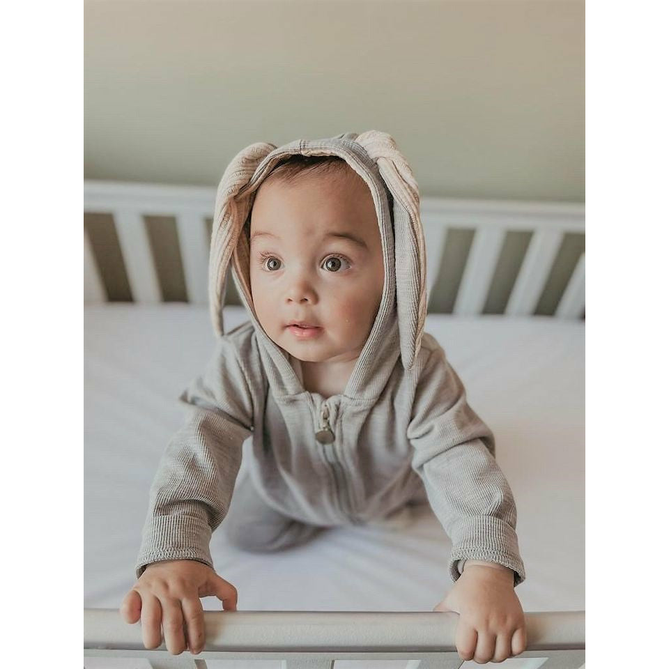 A snuggle bunny baby romper without feet, in grey with a zip up fastening and large bunny ears on the hood.