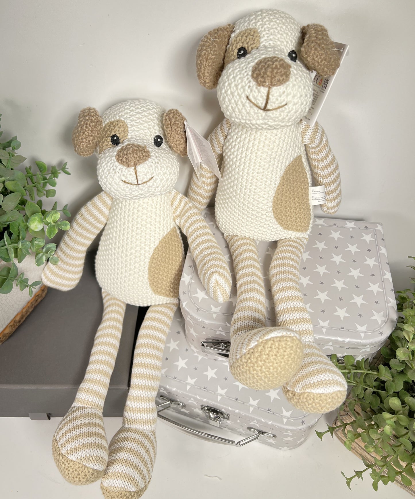 Wilberry knitted soft baby toy puppy in neutral cream and beige with striped arms and legs and a patch over one eye.