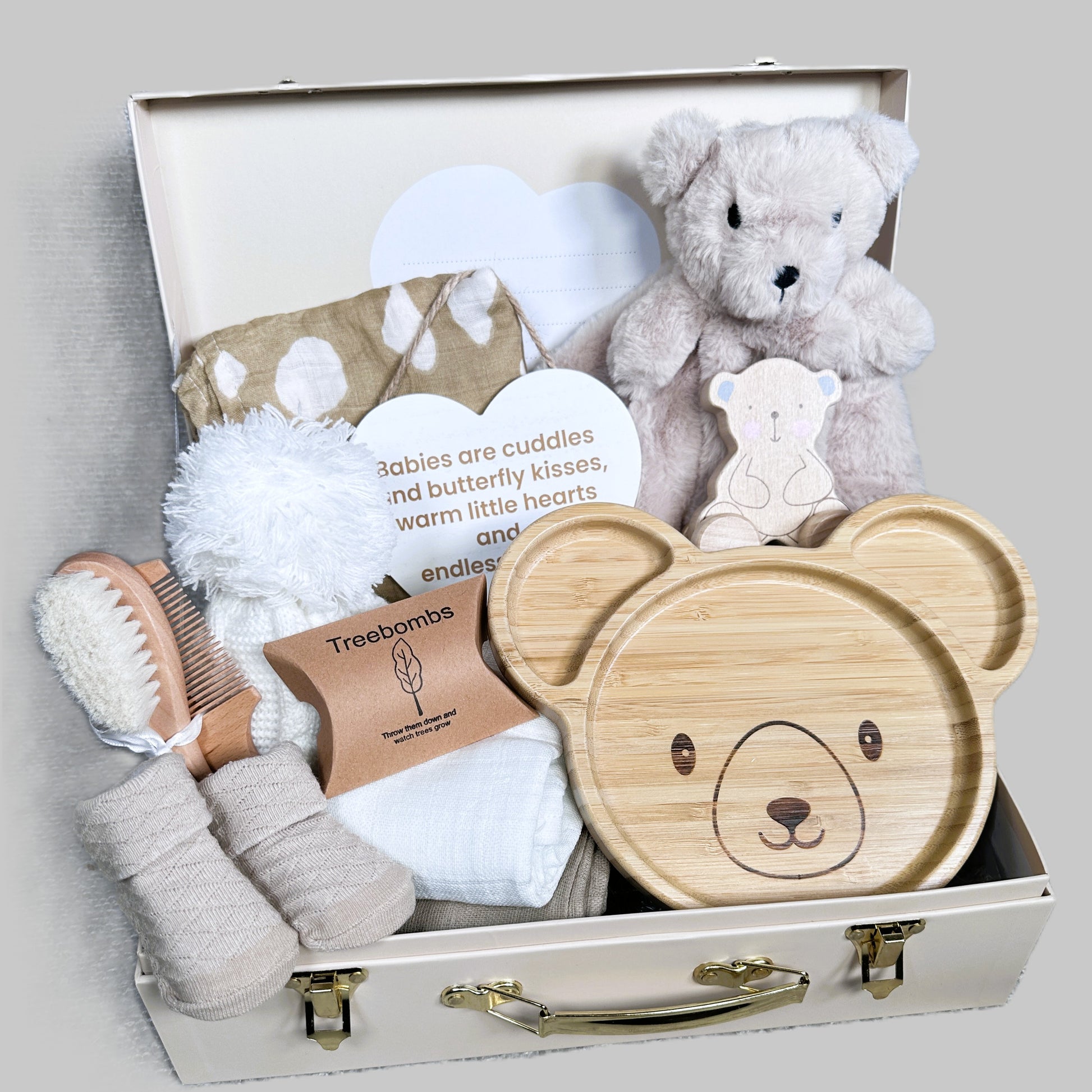 Baby gift set with teddy bear-themed items in a suitcase on a gray background