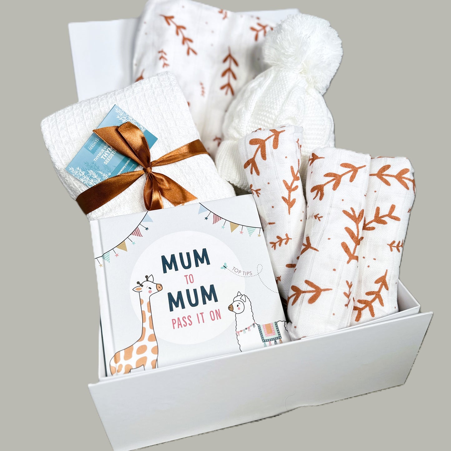Baby hamper with muslins, swaddle blanket and book