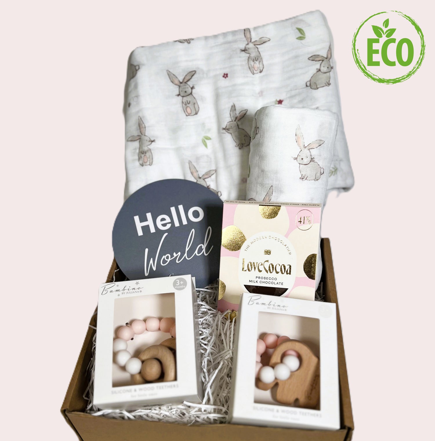 New twin baby girls gift hamper with 2 large muslins with a bunny print and 2 pink and white silicone and wood teething toys, a bar of Prosecco flavoured Love Cocoa chocolate and a baby photography plaque which reads "hello world"