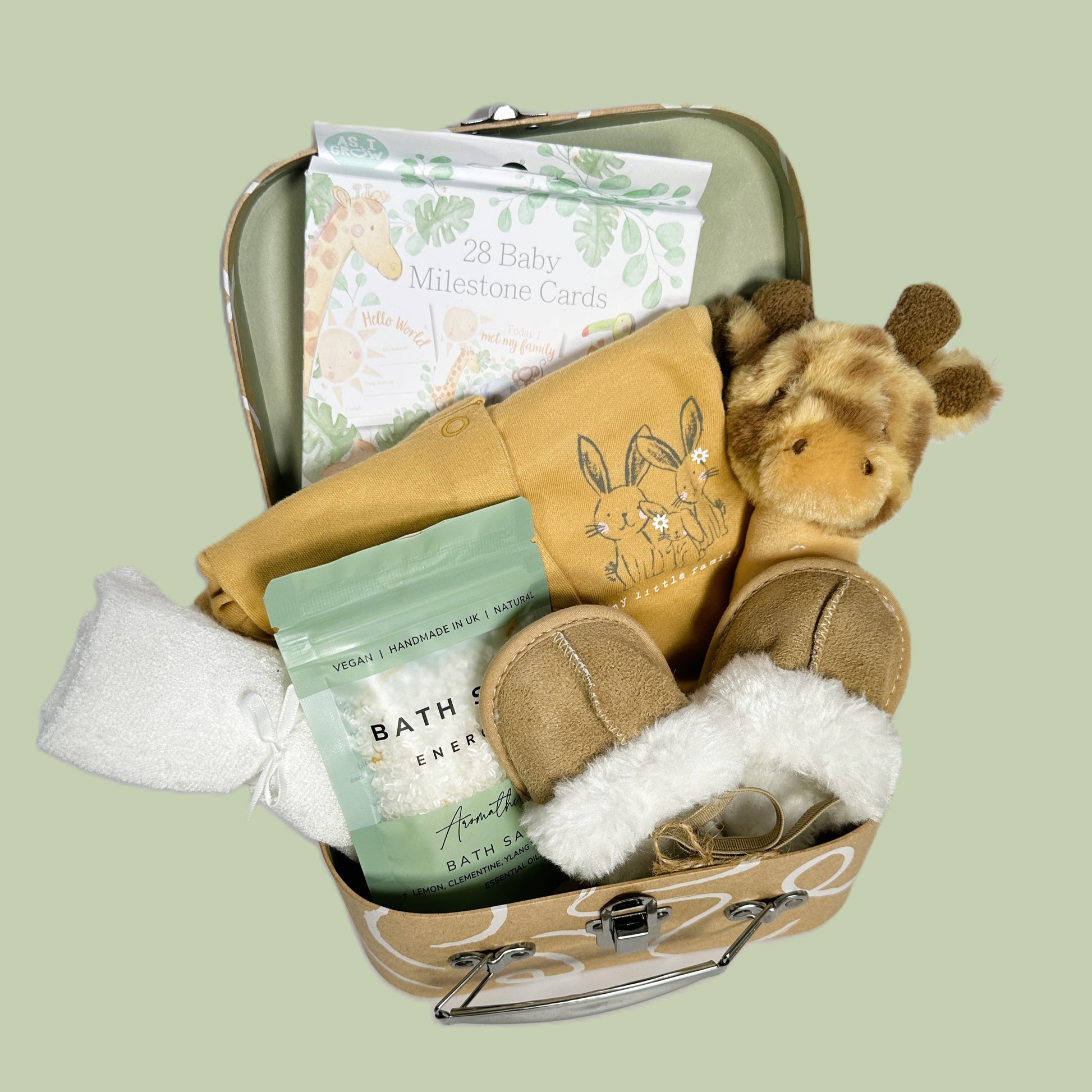 Baby shower gift case with baby rattle, bath salts, baby romper, baby slippers and milestone cards.