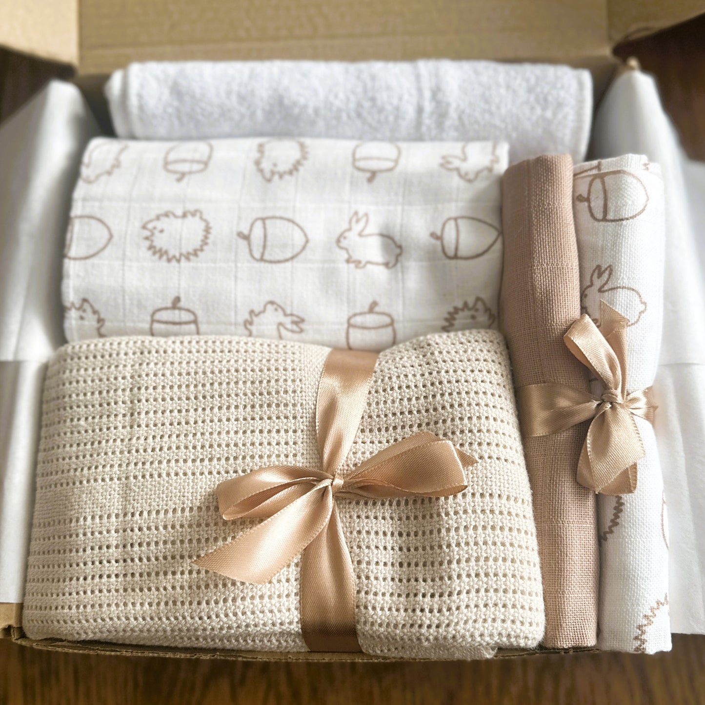 Baby hamper with baby blanket, muslins and a hooded baby towel.