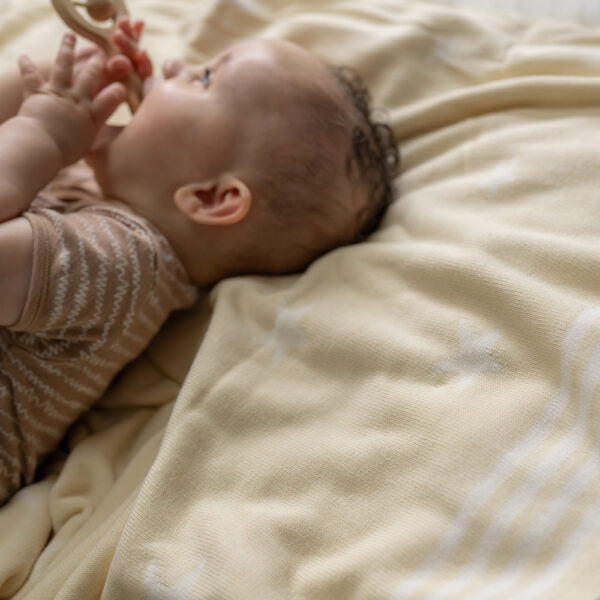 Cream and white baby blanket with star print.