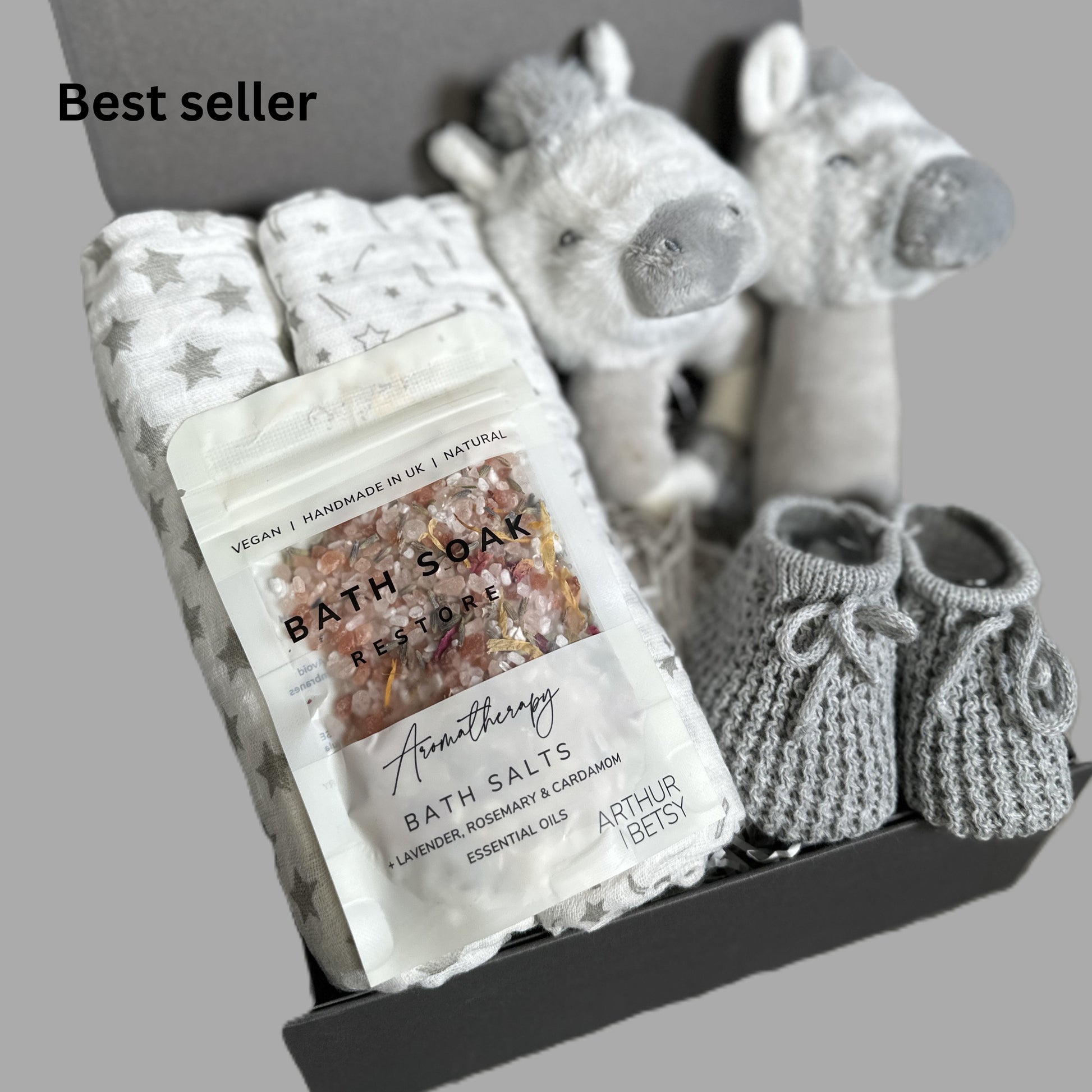Baby gift hamper with, bath salts, and plush zebra baby rattles and muslins in a box.