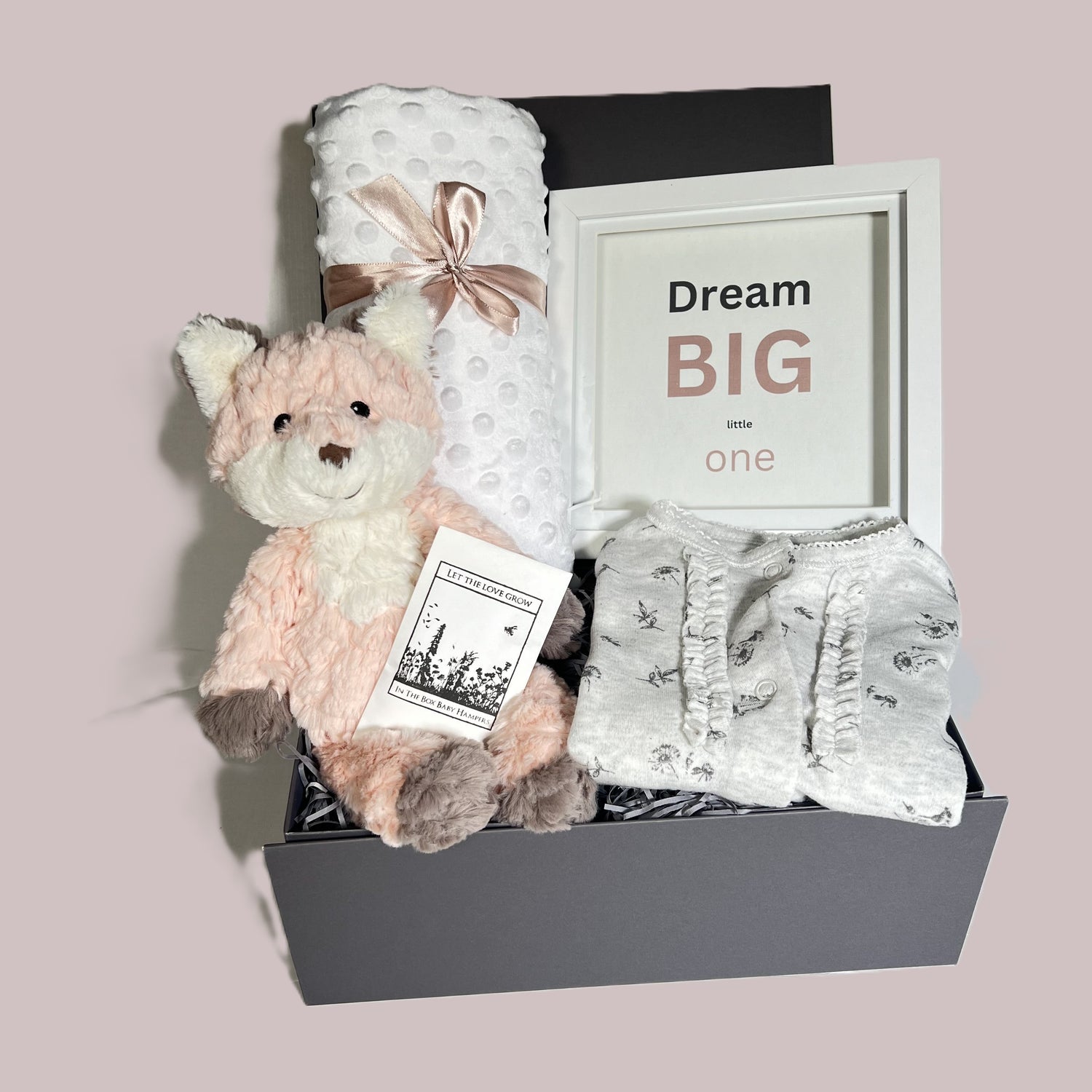 Baby Girl hamper gift in a grey baby keepsake box containing a Mary Meyer blush putty fox soft ty, a white bubble baby blanket, a grey print baby sleepsuit and a nursery picture with the script "Dream big little one".