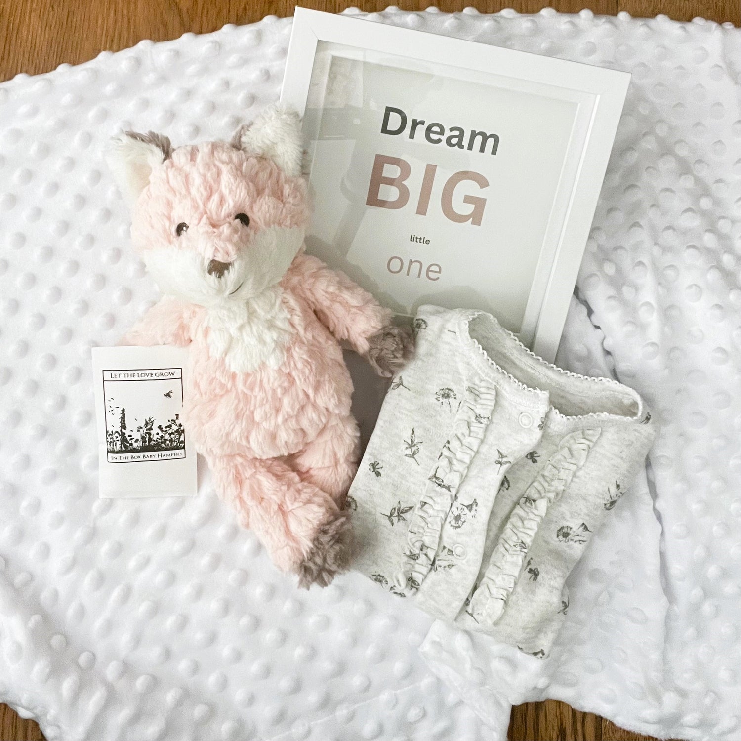 the contents of or "DReaming big baby hamper. I x Mary Meyer blush fox soft toy, a grey print baby sleepsuit,a white bubble baby blanket and a nursery picture with the txt "Dream big little one"