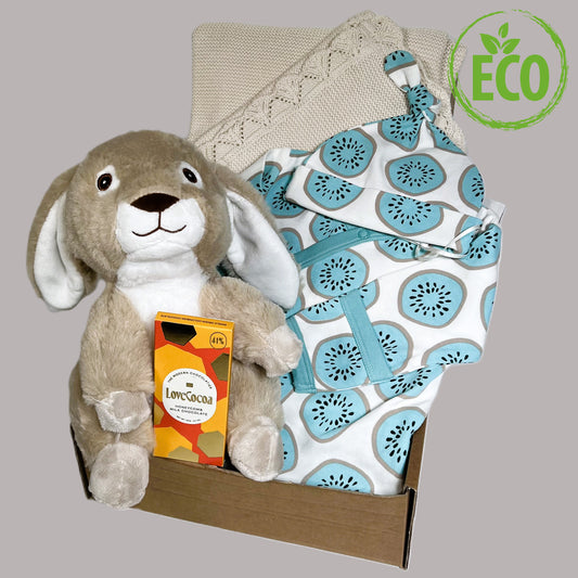 A baby shower gift with an organic cootin baby sleepssuit and matching knot hat with a blue kiwi print, a bunny soft baby toy, a bar of Love Cocoa chocolate and a fine cotton baby blanket in taupe.