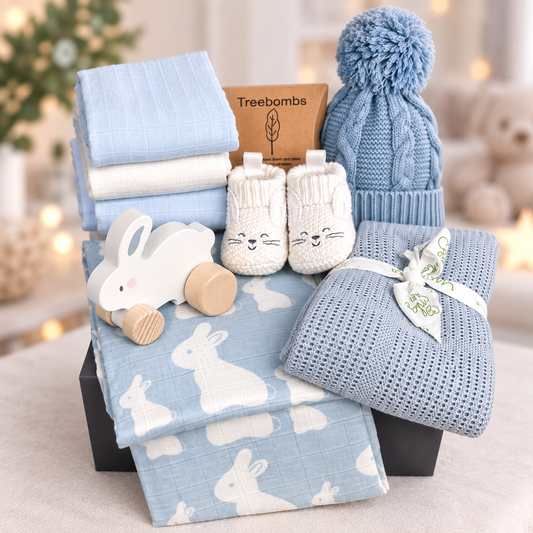 New baby hamper with blue baby blankets, baby hat and wooden toy