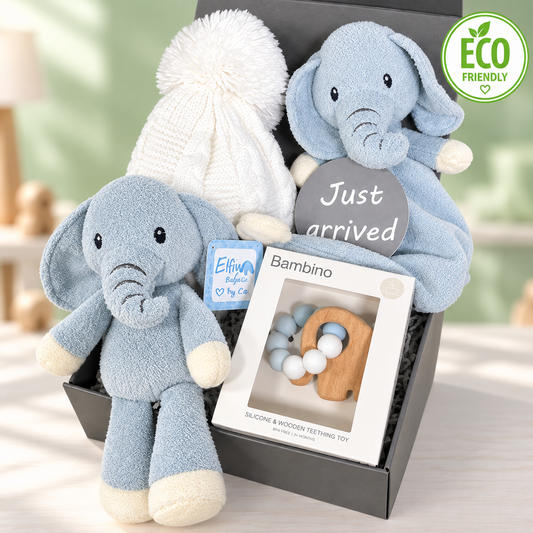  Blue baby hamper with a blue elephant baby rattle and a baby comforter, a Bambino teething ring and a white baby pompom hat in a grey gift box