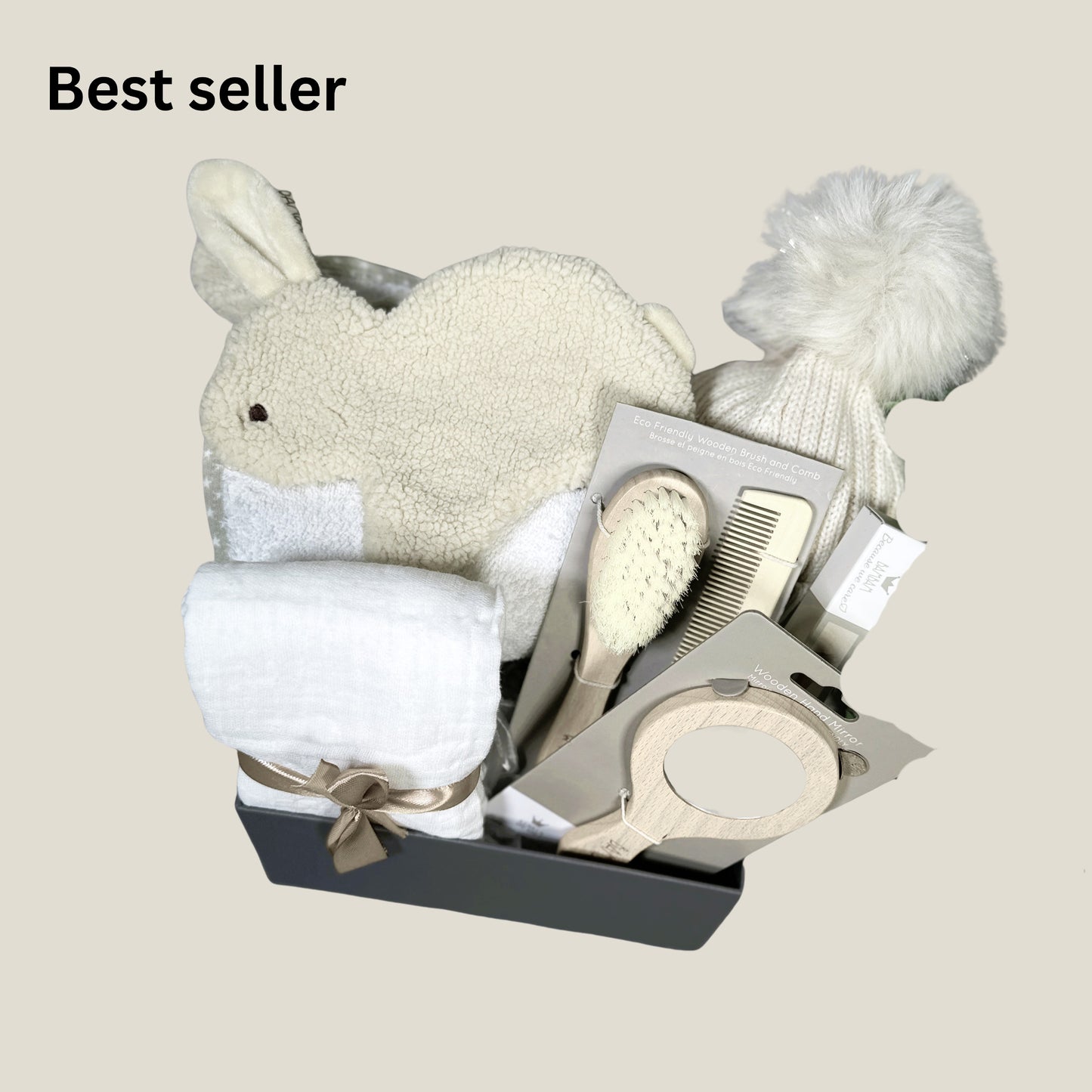 A neutral new baby hamper with a bunny baby Tuttle, a baby hooded tower and baby hair brush set in a baby keepsake box