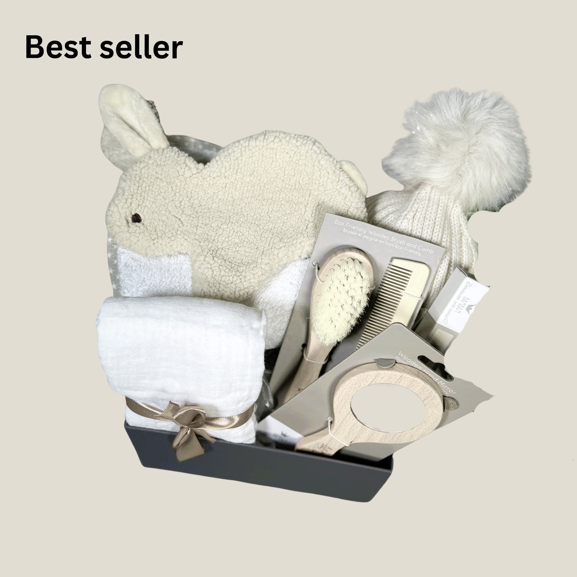 A neutral new baby hamper with a bunny baby Tuttle, a baby hooded tower and baby hair brush set in a baby keepsake box