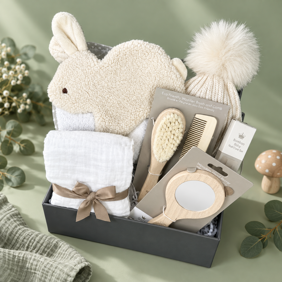 A neutral new baby hamper with a bunny baby Tuttle, a baby hooded tower and baby hair brush set in a baby keepsake box.