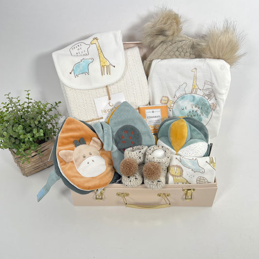 Luxury unisex new parents hamper gift containg a white Hippychick Cellular cotton baby balnlet, an organic cotton layette set "We love our planet", apair of chrocheted baby booties with pom poms a a nattou activity ball and a Nattou sensory fabric baby book