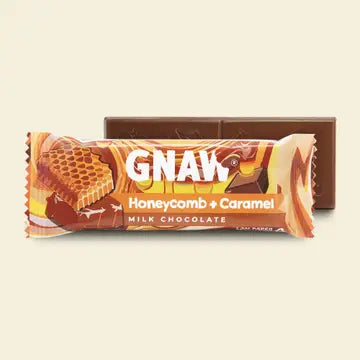 Gnaw milk chocolate bar with honeycomb and caramel flavour packaging on a beige background