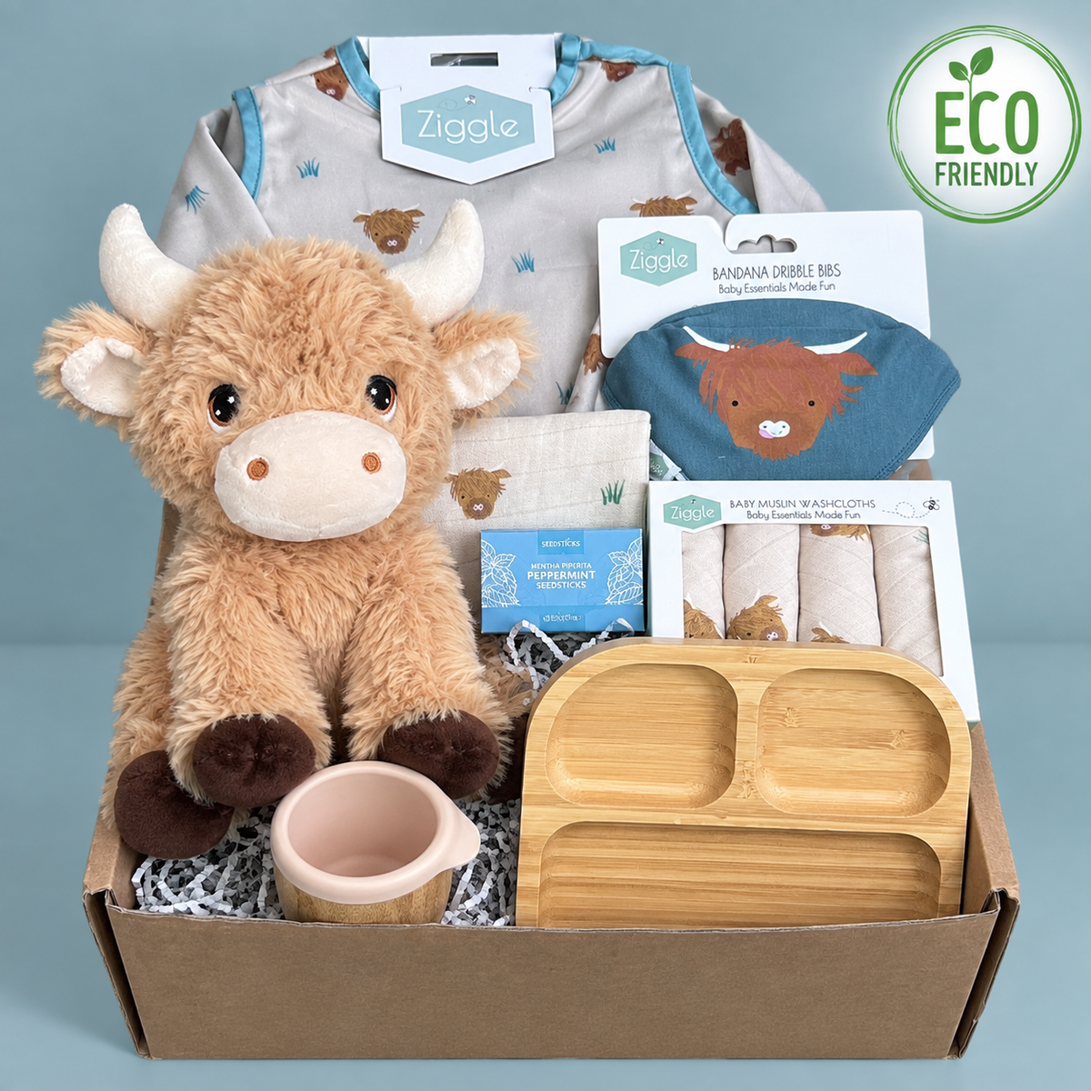 A new baby gift with Keeleco highland co soft baby toy, bamboo baby cup and plate, Ziggle highland cow coverall, bib and baby wash cloths