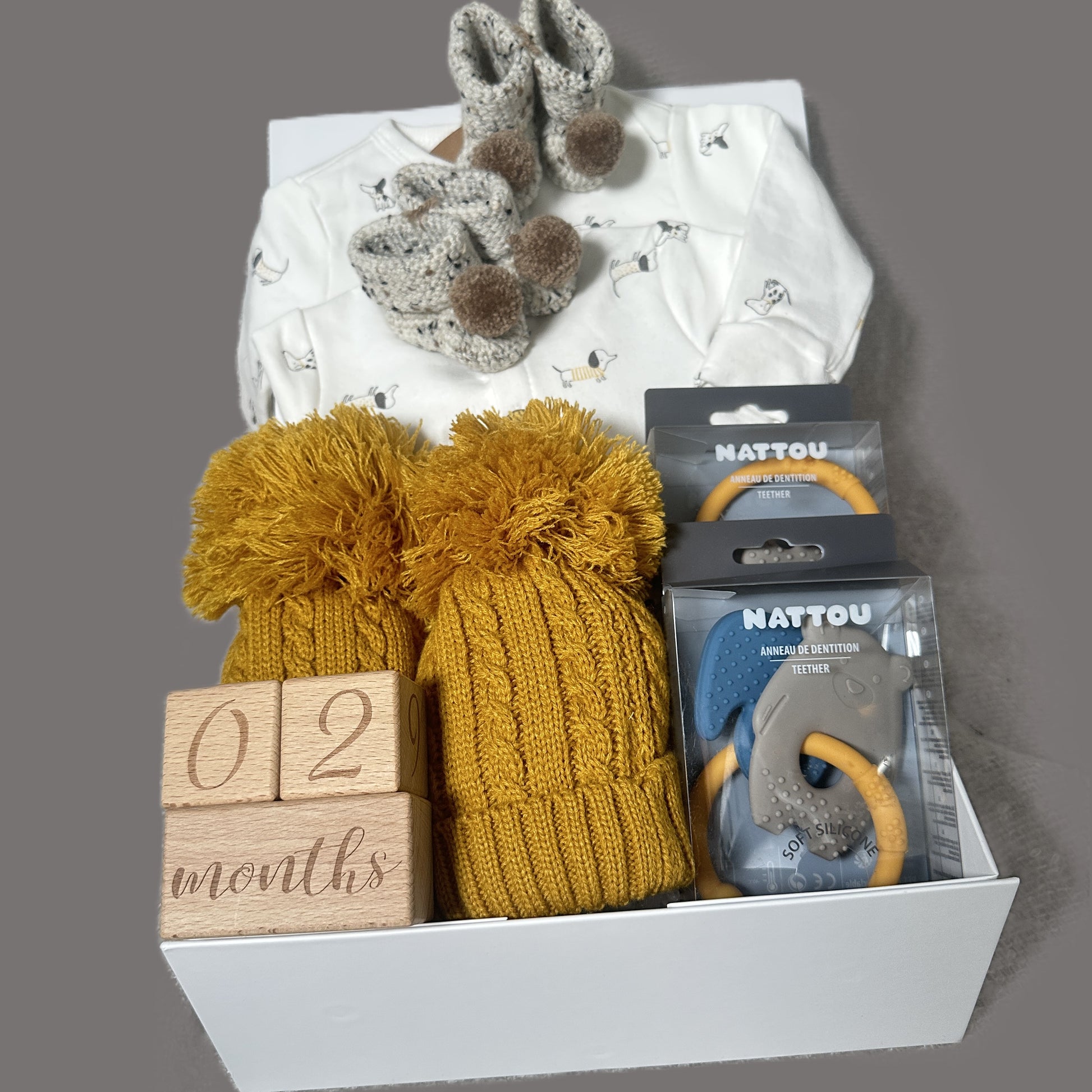 Twin baby hamper gift with baby wear, baby booties and baby teethers.