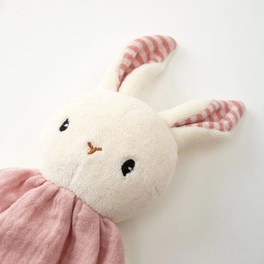 Plush toy rabbit with pink dress on a white background