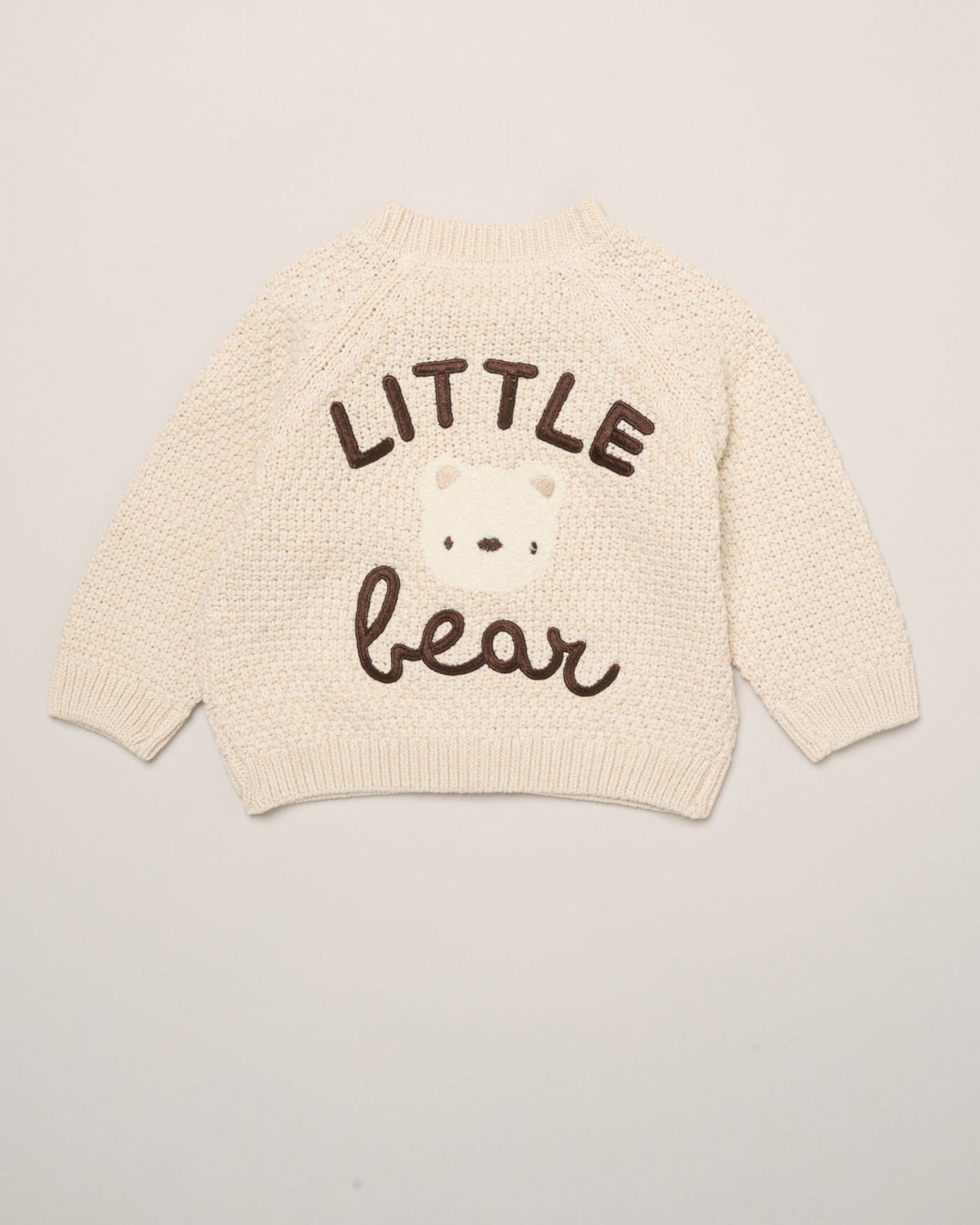 Cream baby cardigan with 'LITTLE bear' text on a light gray background