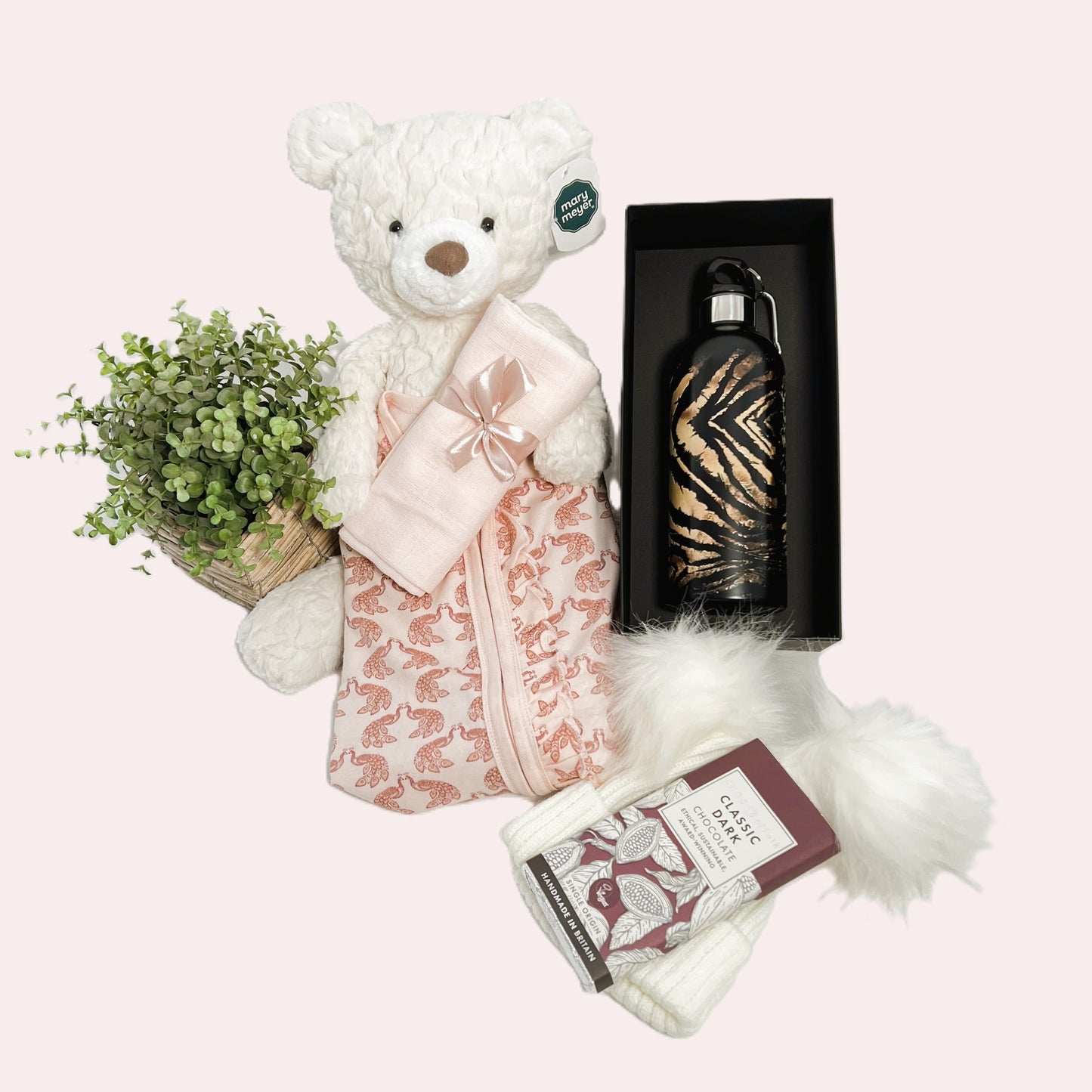 New Parents gift, this baby girl hamper comes in a grey baby keepsake box containing a Roberto Cavelli wtaer bottle, an organic zipped baby sleepsuit, a Mary Meyer cream Teddy bear, a handcrafted baby journal, a baby pompom hat and a bar of Choc Affair chocolate.
