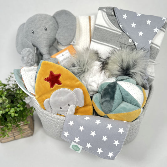 Luxury baby shower gift containing a knitted elephant toy, a cloth sensory book and matching activity ball, a cellular baby blanket, baby pompom hat, zipped baby sleepsuit and a baby bib and baby knot hat.