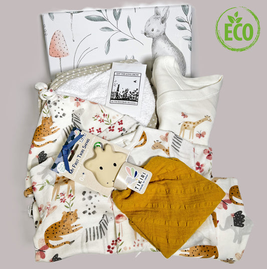 Baby shower gift in a handmade baby keepsake box with a cotton layette set, a mustard Tikiri rubber and cotton baby teether, a hooded baby towel and some wildflower seeds.