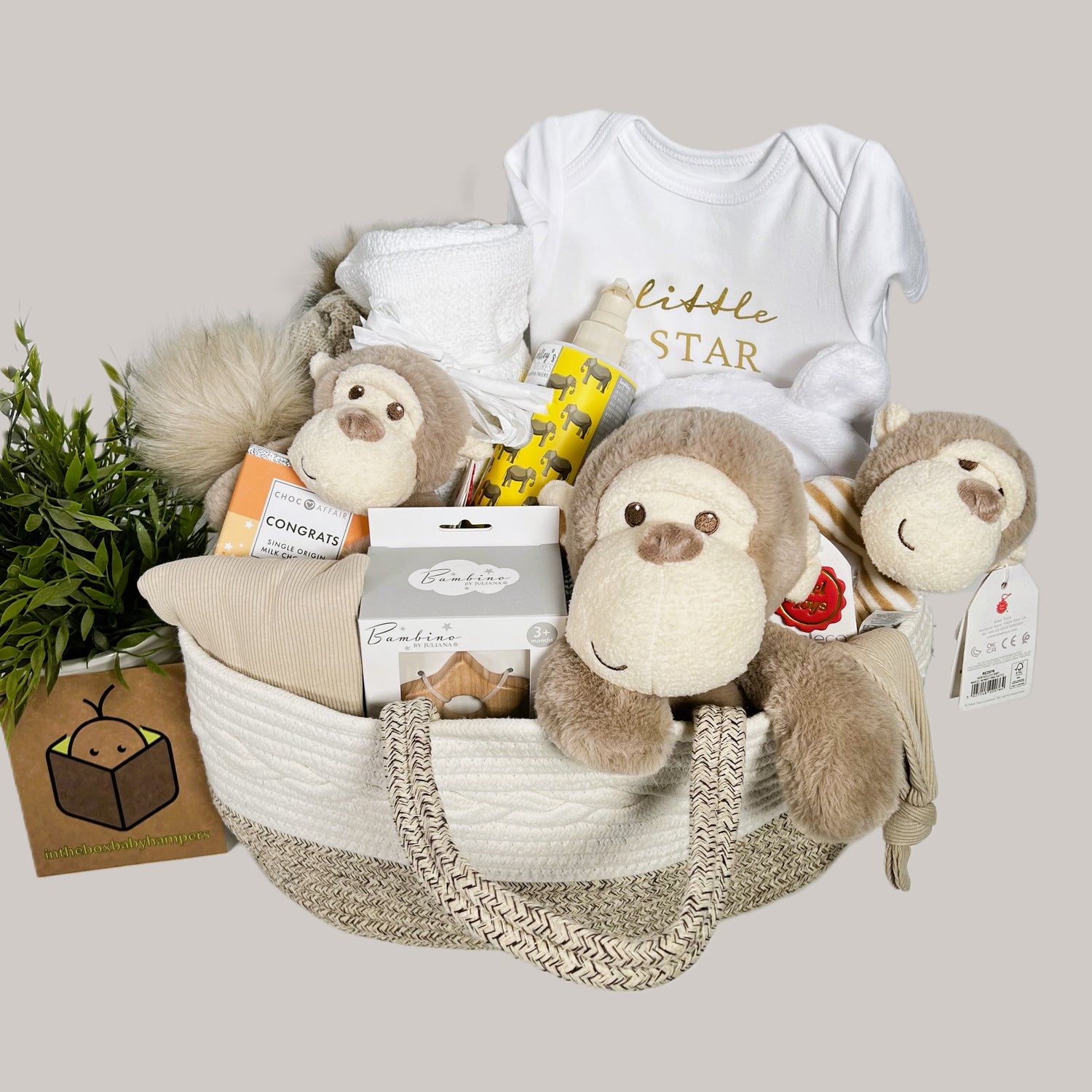 Monkey themed new baby nappy caddy baby hamper gift containing thre keeleco monkey soft toys one of which is a monkey rattle, all are made from recycled plastics, a nappy caddy , a white baby dressing gown, a wooden star teether, baby body lotion, congratulations chocolate.