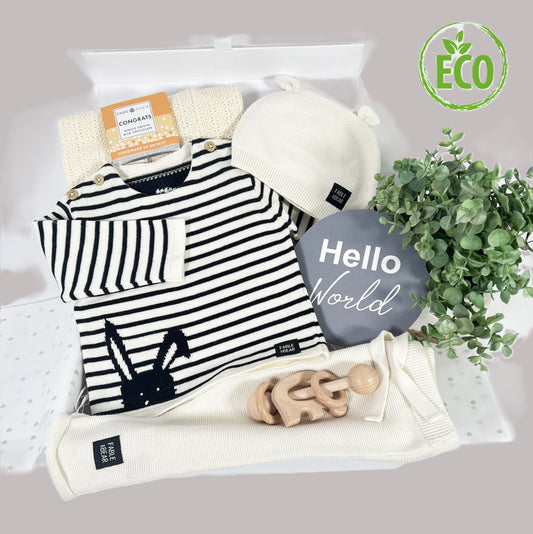 This luxury neutral new baby gift  organic cotton baby clothing set , a baby jumper with a bear face and hand stitched facial features, a matching baby hat and baby leggings, a cotton baby cellular baby blanket, a elephant Montessori baby rattle in beech , a large "Hello world " photography disc and a white baby keepsake box.
