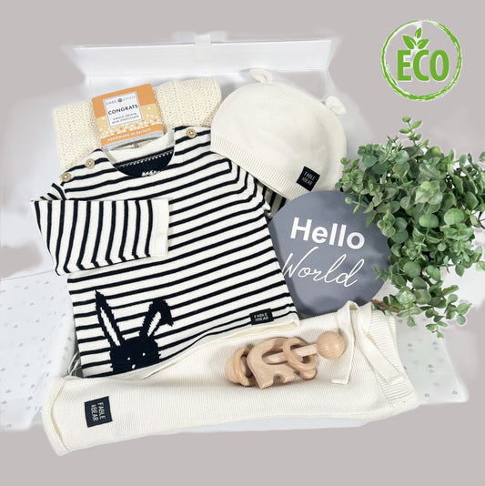 This luxury neutral new baby gift  organic cotton baby clothing set , a baby jumper with a bear face and hand stitched facial features, a matching baby hat and baby leggings, a cotton baby cellular baby blanket, a elephant Montessori baby rattle in beech , a lage "Hello world " photography disc and a white baby keepsake box.