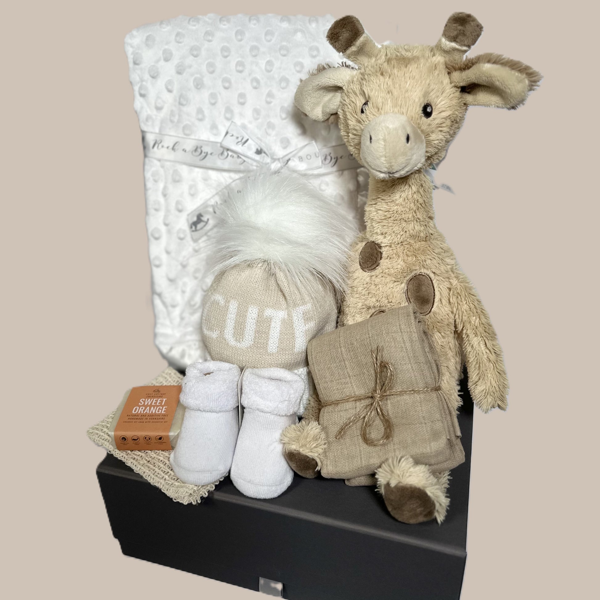 Gus the giraffe baby hamper with white baby blanket and "cute" baby pompom hat.