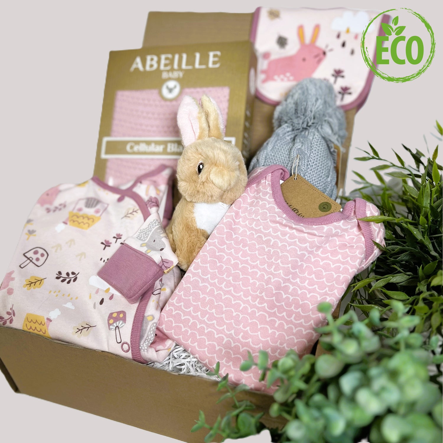 Pink new baby girl gift, eco friendly contents including organic cotton 3 piece baby clothing set with fold over cuffs and feet, a pink cotton cellular baby blanket, a grey baby pompom hat and a cute Eco-Nation bunny soft baby toy