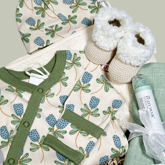 Organic cotton baby romper with  green and blue flower print, matching bay knot hat, a baby bootees in a hamper box.