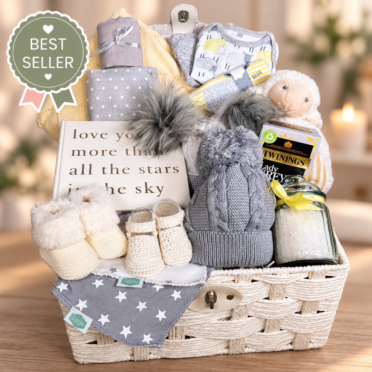 Neutral baby gift hamper basket with baby clothes, baby soft toy, tea, baby blanket and baby shoes.