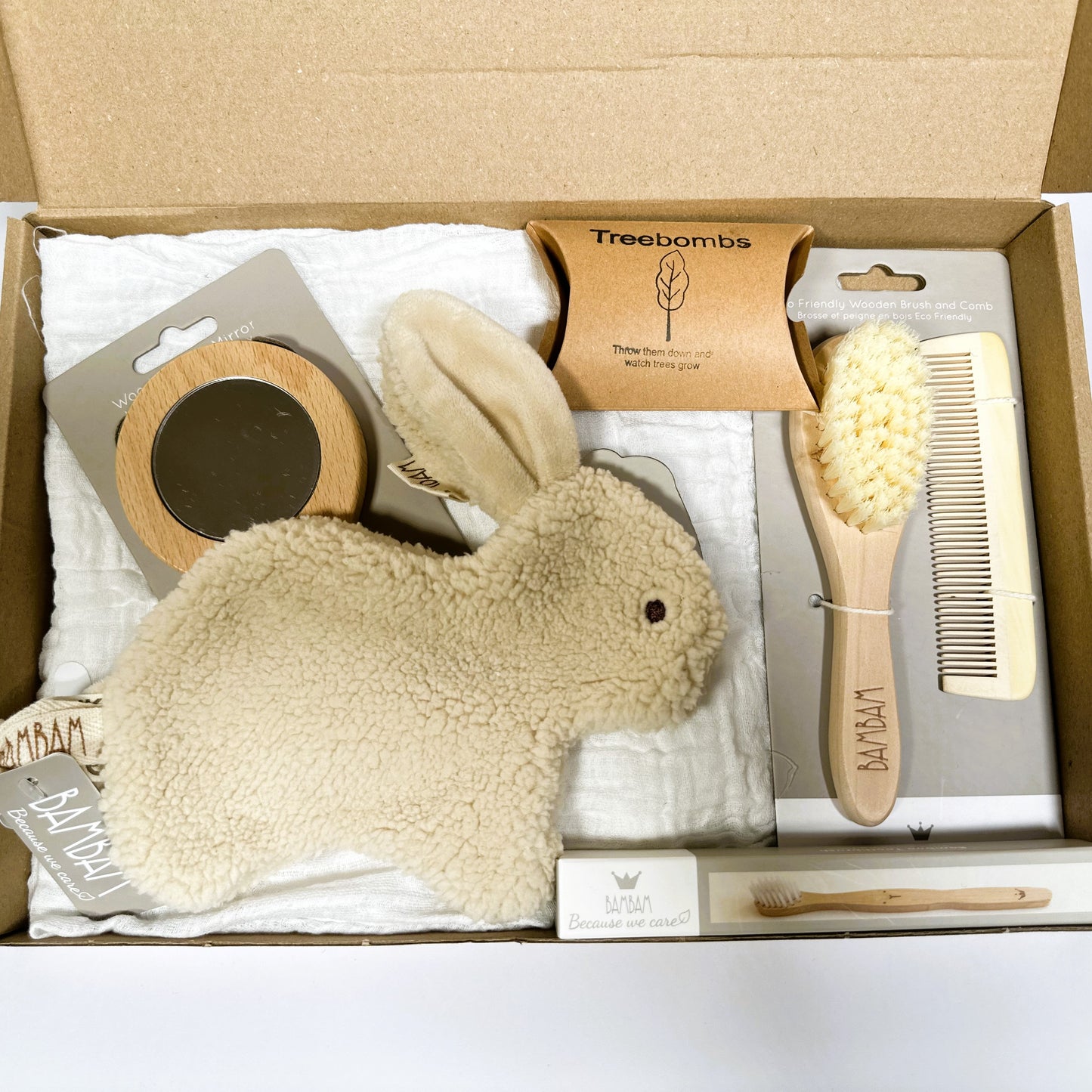 a new baby gift containing a Bambam Bunny Tuttle, wooden baby hairbrush and comb se, baby mirror, White baby muslin and a bamboo toothbrush.