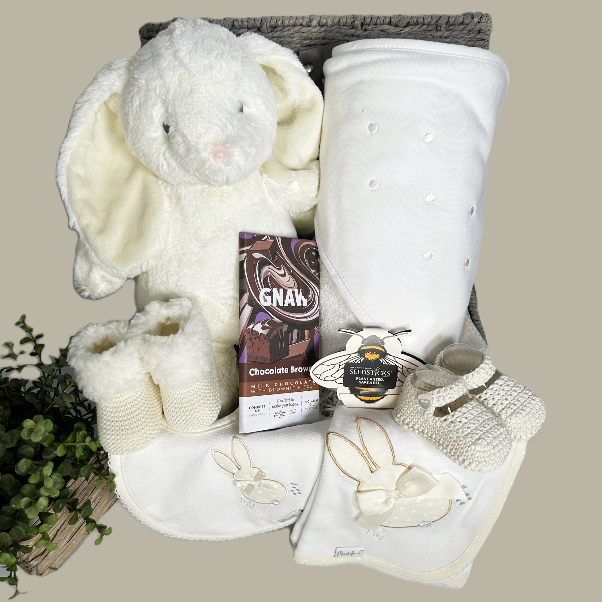 Neutral new baby gift hamper with bunny soft toy, baby booties and a cotton hooded baby towel.