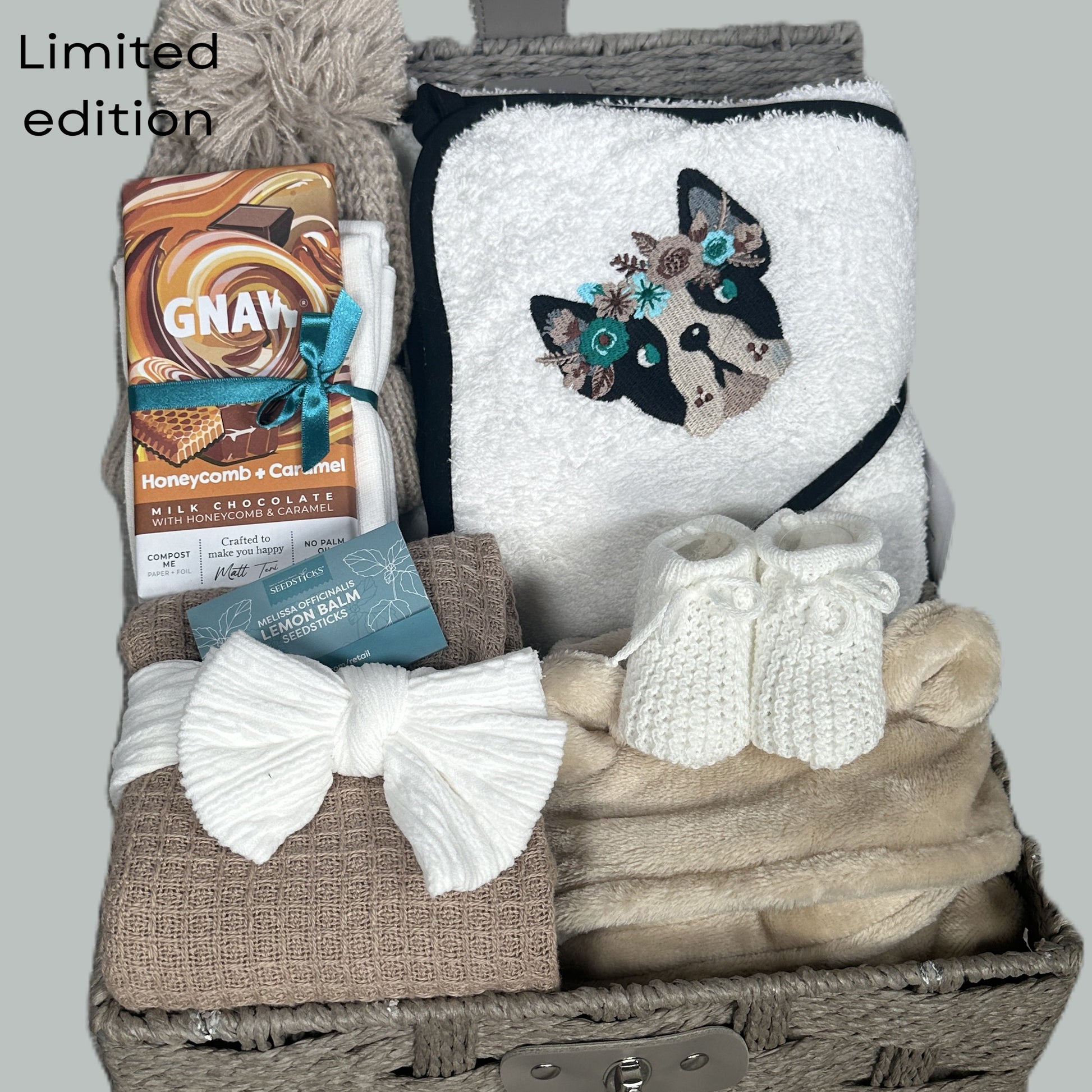 New Baby Girl hamper with bulldog embroidered baby hooded towel, blanket, and chocolate bar on a grey background