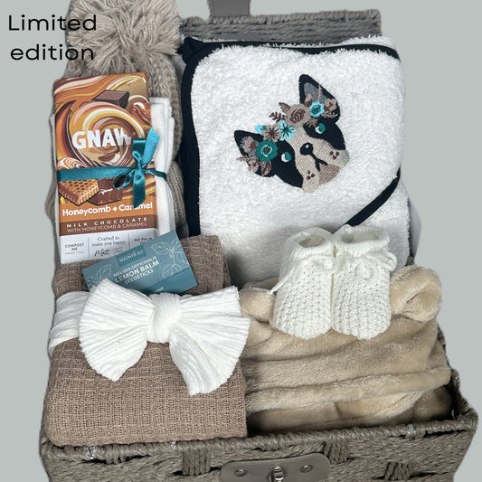 New Baby Girl hamper with bulldog embroidered baby hooded towel, blanket, and chocolate bar on a grey background