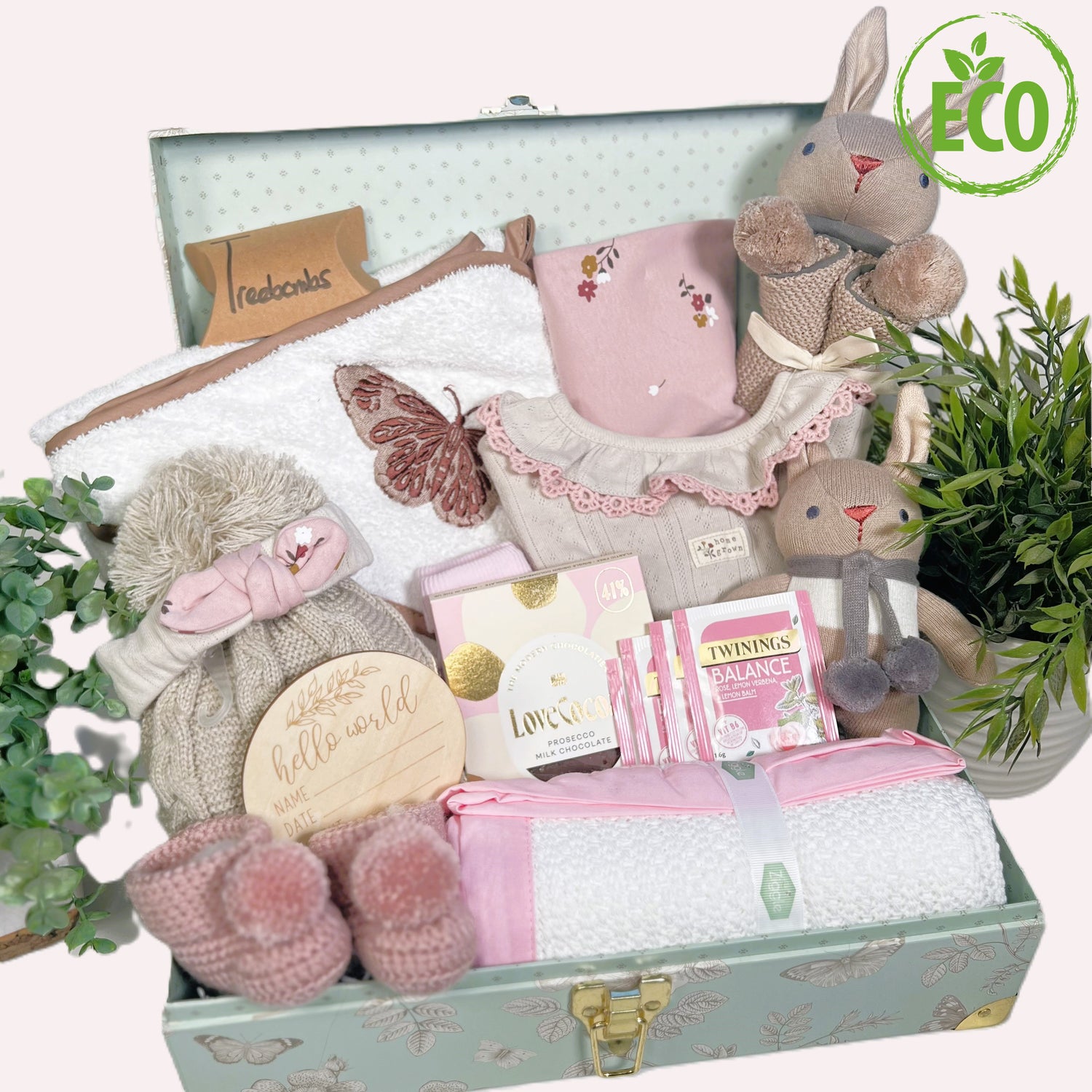 This baby girl hamper is full of Eco friendly new baby esstentisl including organic cotton baby layette set, cotton hooed baby towel, soft baby toys, a cotton baby blanket, crocheted baby booties and treats for the new mummy