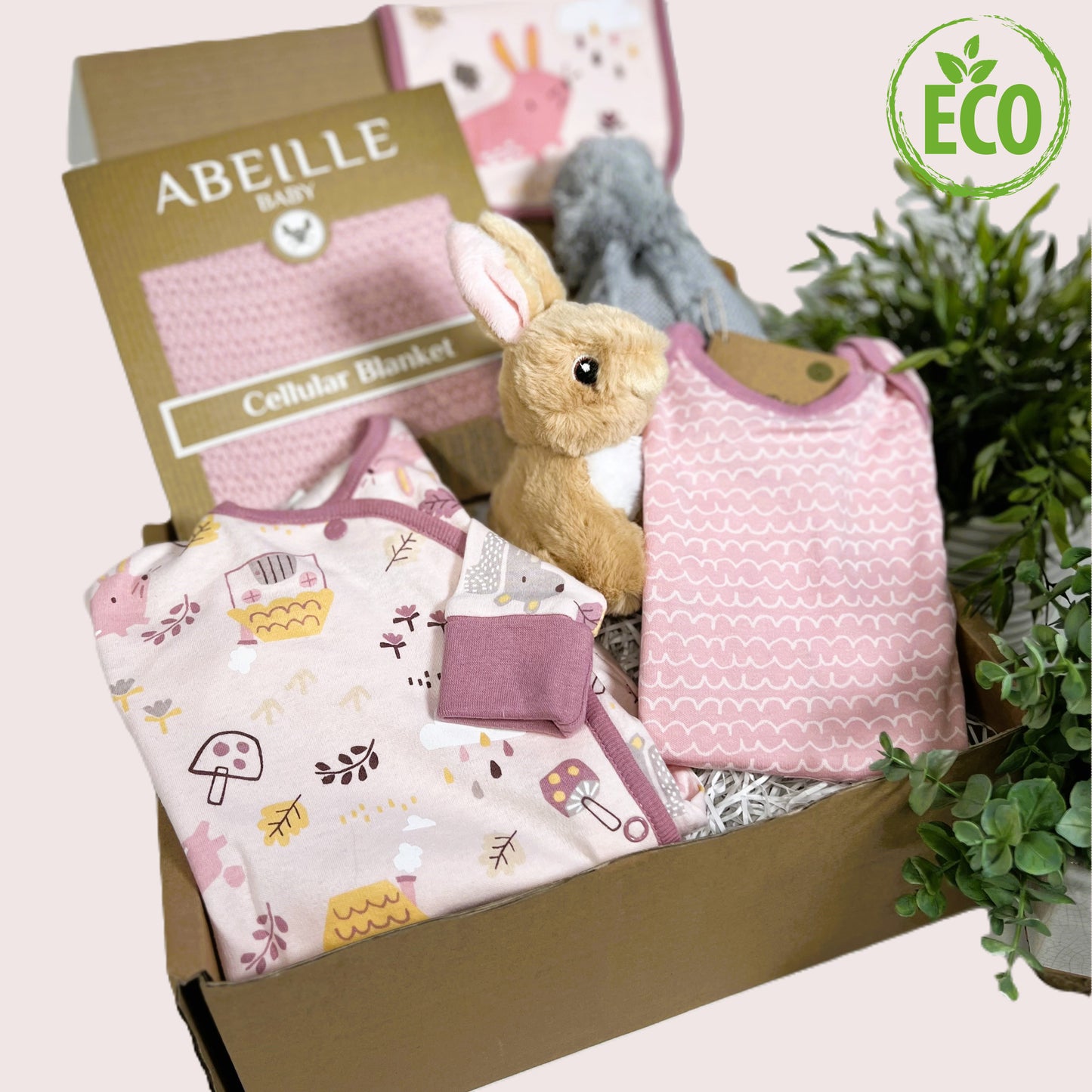 Pink new baby girl gift, eco friendly contents including organic cotton 3 piece baby clothing set with fold over cuffs and feet, a pink cotton cellular baby blanket, a grey baby pompom hat and a cute Eco-Nation bunny soft baby toy
