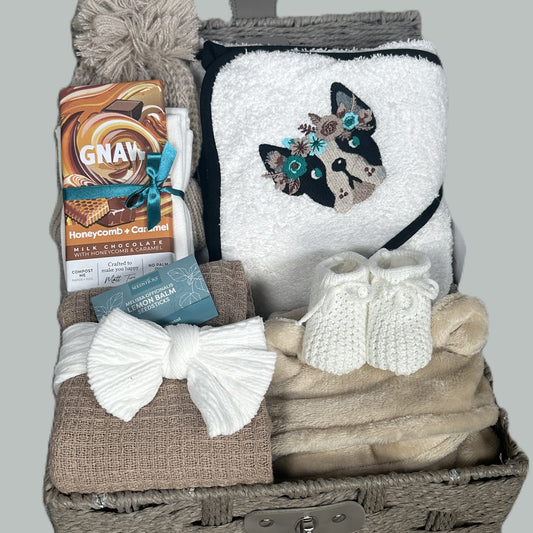 New Baby Girl hamper with bulldog embroidered baby hooded towel, blanket, and chocolate bar on a gray background