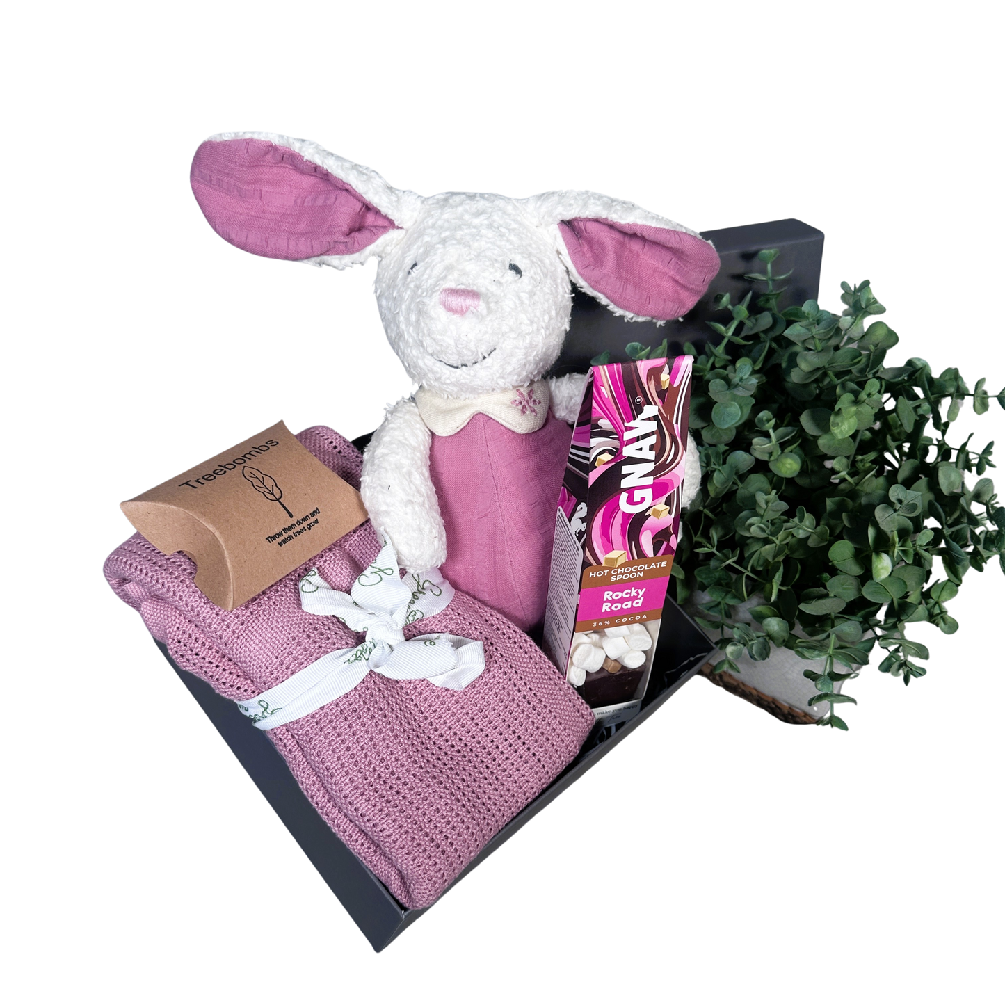 pink baby girl hamper with bunny soft toy, baby blanket and hot chocolate stirrer.