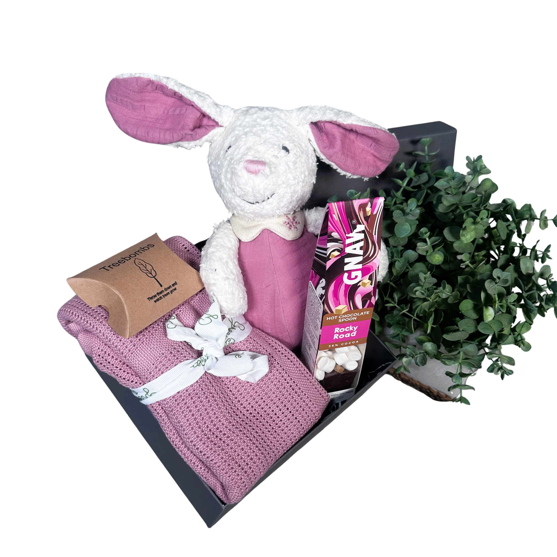 pink baby girl hamper with bunny soft toy, baby blanket and hot chocolate stirrer.