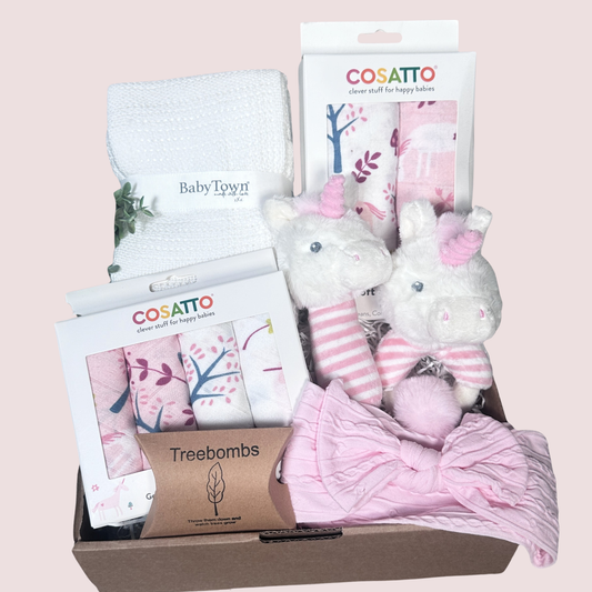 pink baby girl hamper with unicorn print muslins and baby washcloth and unicorn baby rattles