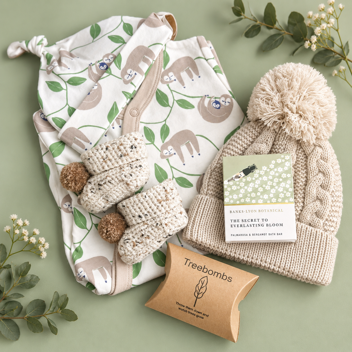 Neutral baby hamper gift with sloth print baby grow and hat and taupe baby pompom hat and baby booties